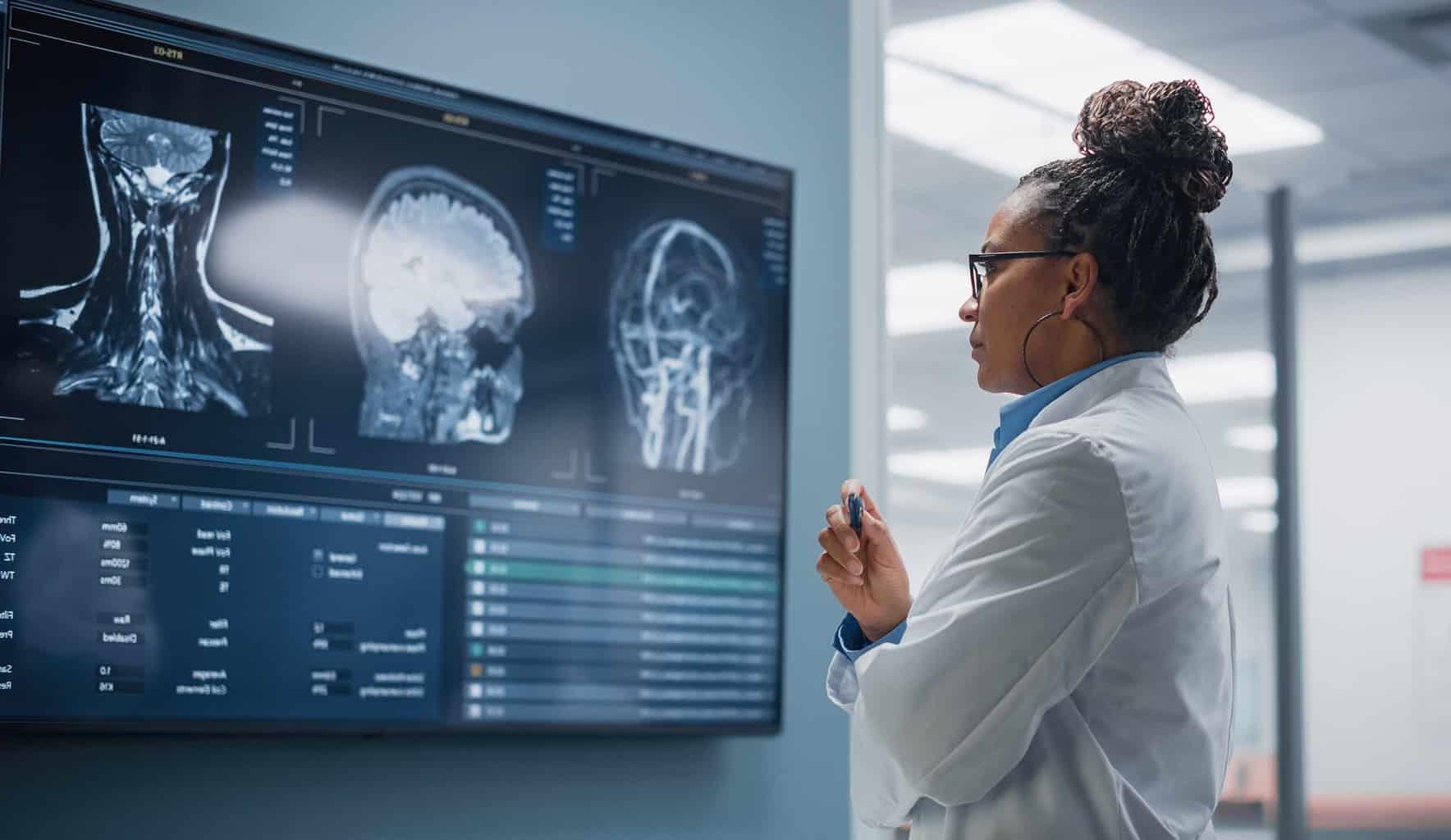 黑人女性技术人员正在为明尼阿波利斯的神经科医生检查亨廷顿舞蹈症的扫描结果, 神经病学MN, 神经学家明尼苏达州